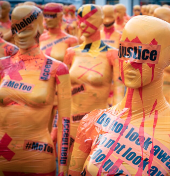 Rows of manikins wrapped in tape, some with red X's and some with their eyes covered, one with justice over the eyes to represent the statistics of sexual assault on campus and in the community